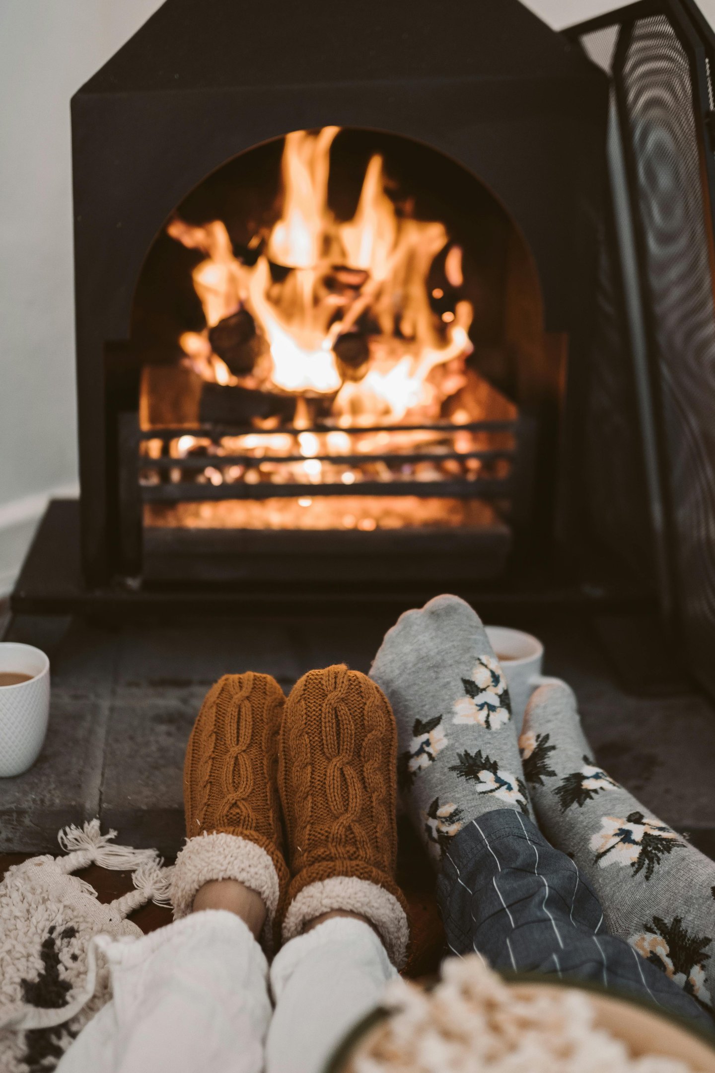 A cozy living room with a warm fireplace, thick blankets, and energy-efficient space heaters,